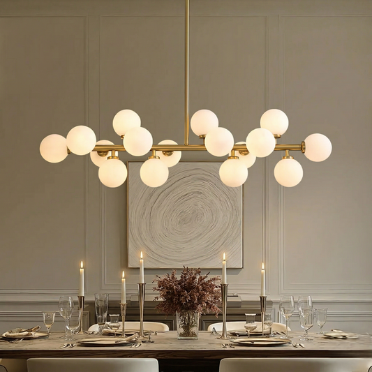 Milky Moon Dining Chandelier hanging above a dining table with candles and decor.